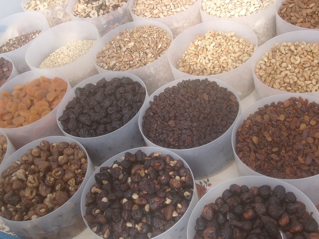 several bowls of different types and colors of nuts