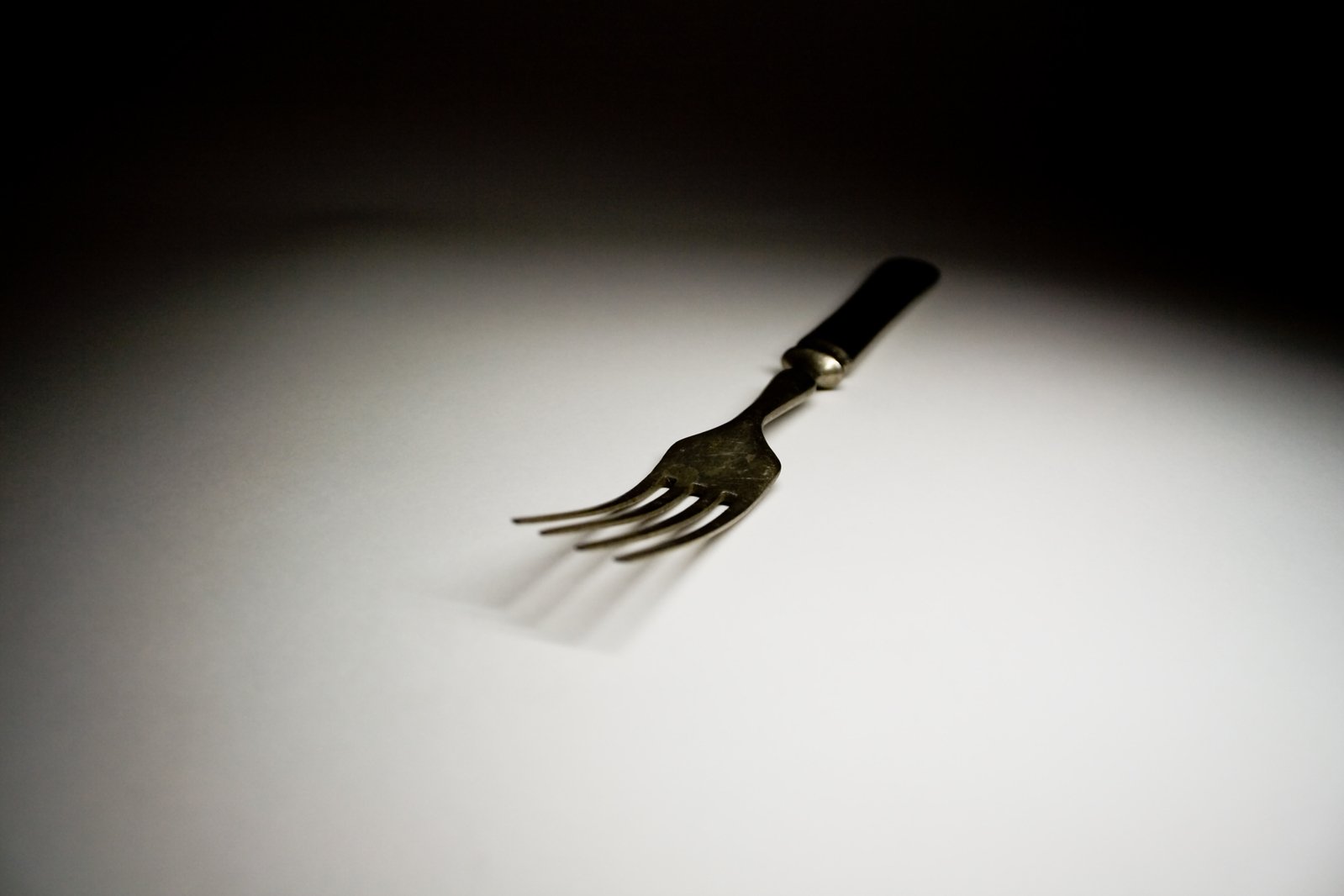 a fork with long nails on a white table