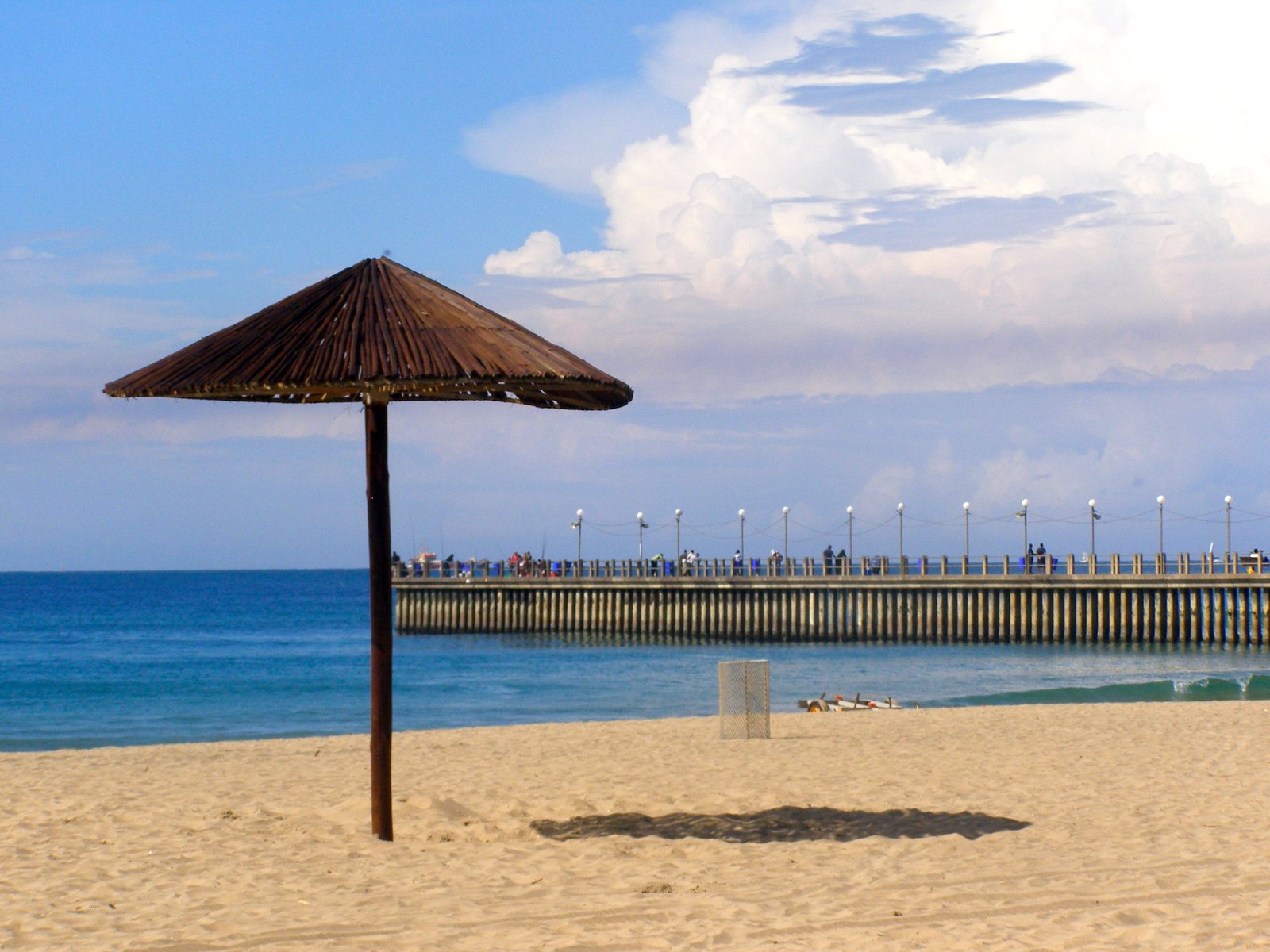 a thatched umbrella sitting on top of a sandy beach