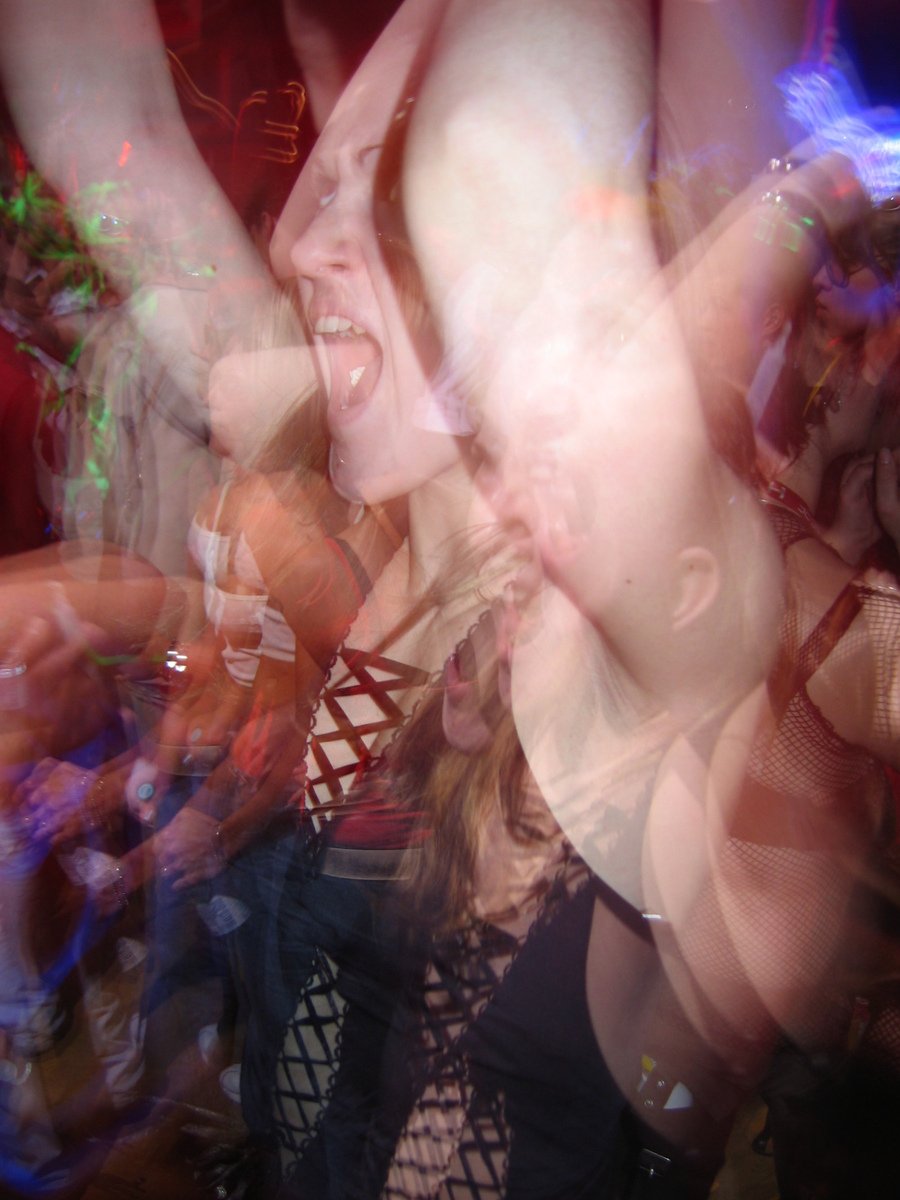 blurry image of a woman dancing at a party