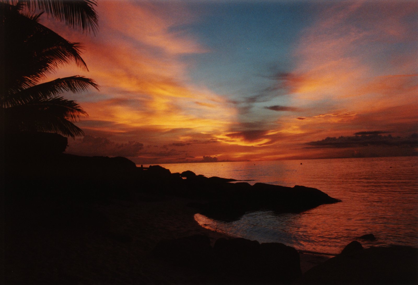 the sun is setting over a bay filled with rocks