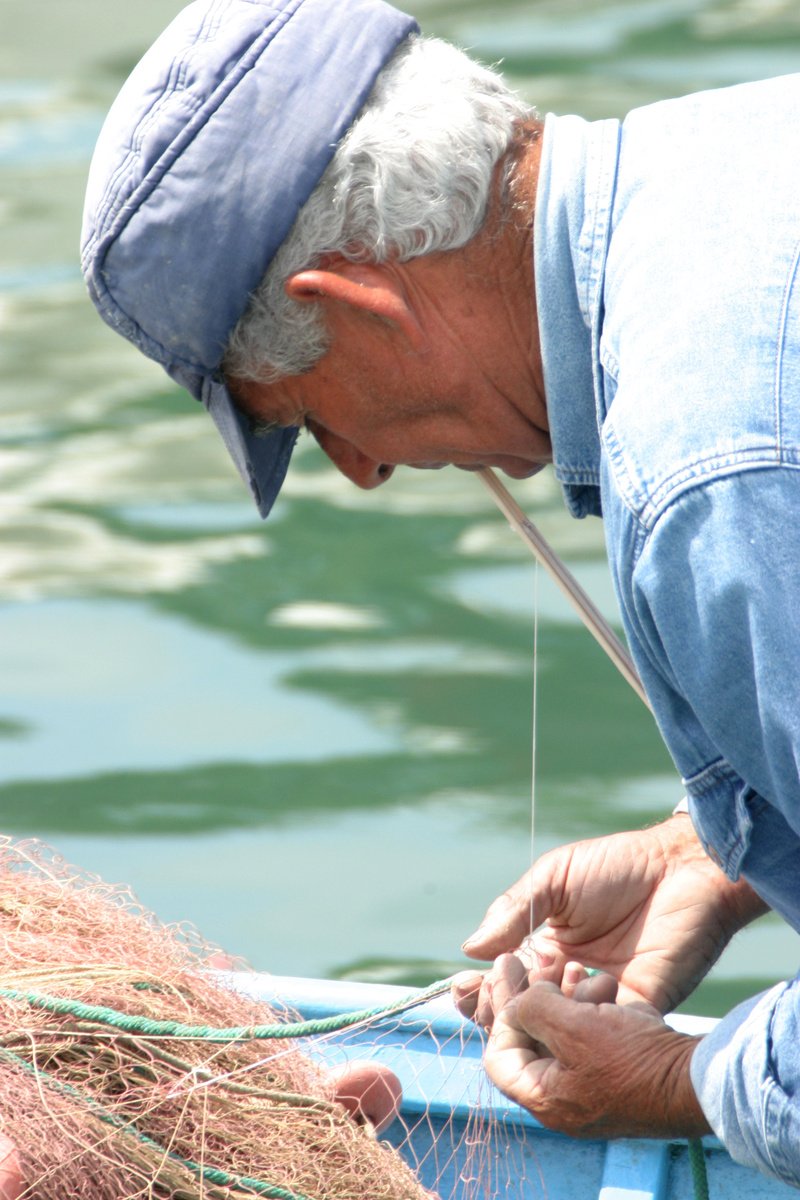 an older man holding the fishing nets in his hands
