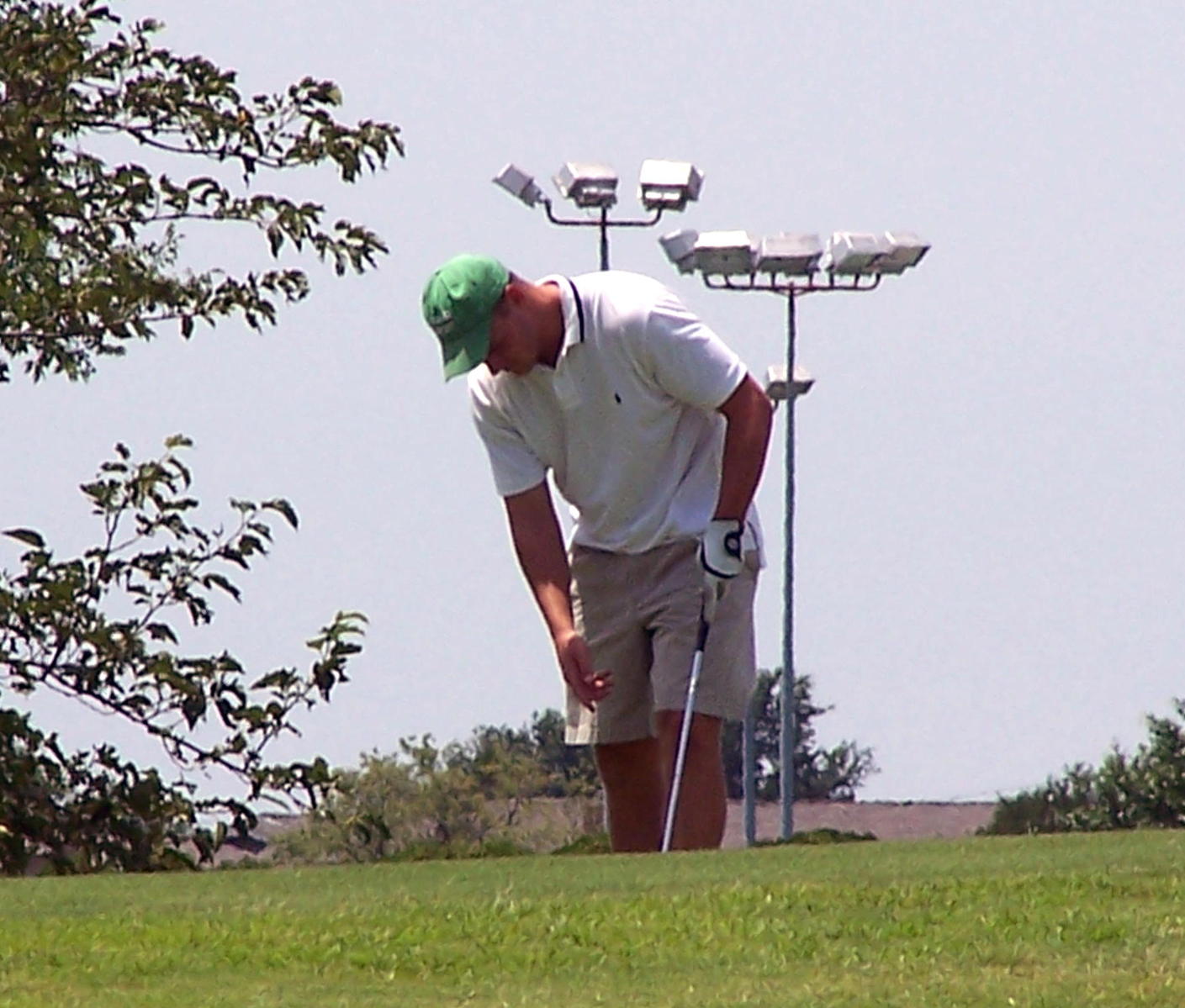 a man with a golf club standing on the green