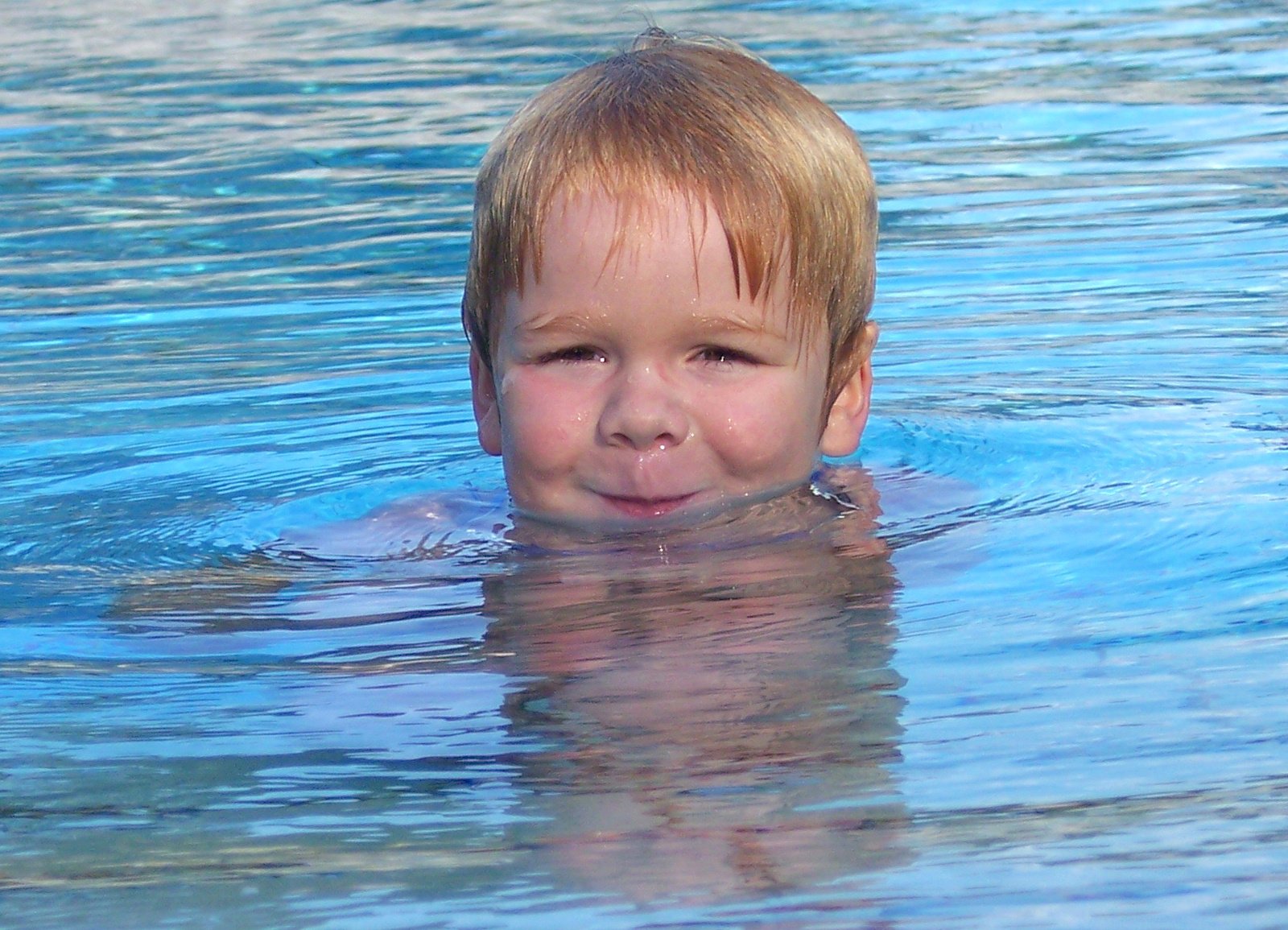  in the water smiling with his face pressed over