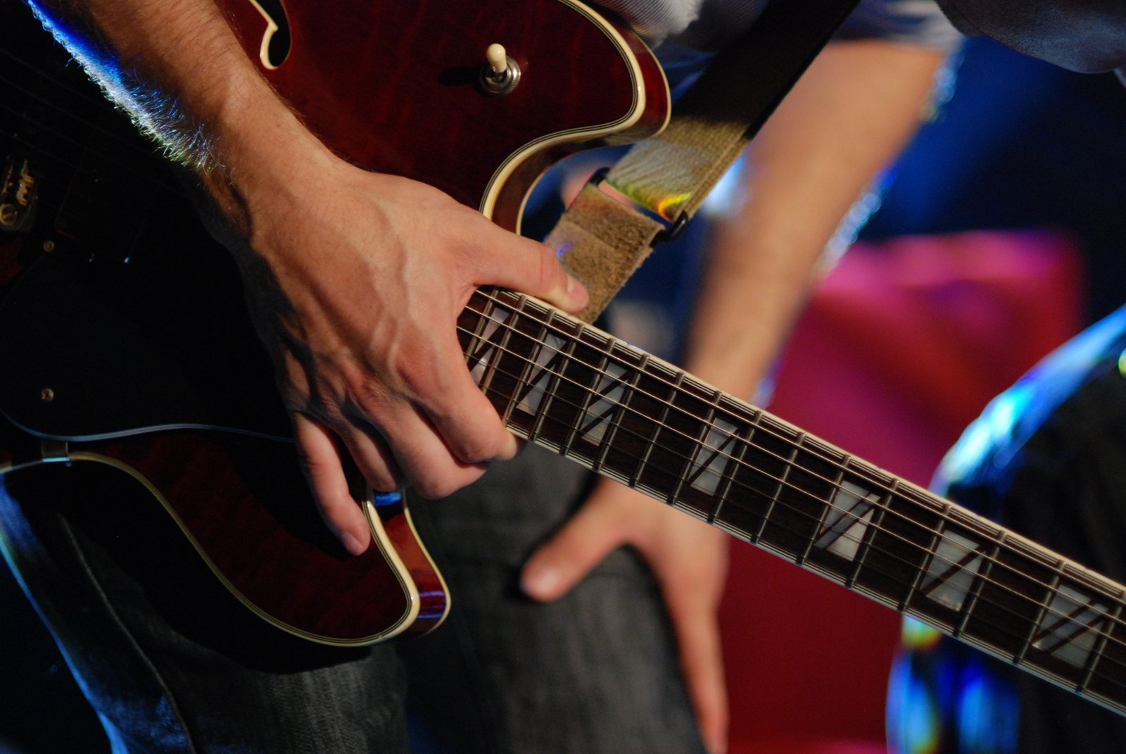 a person holding on to a brown guitar in their hands