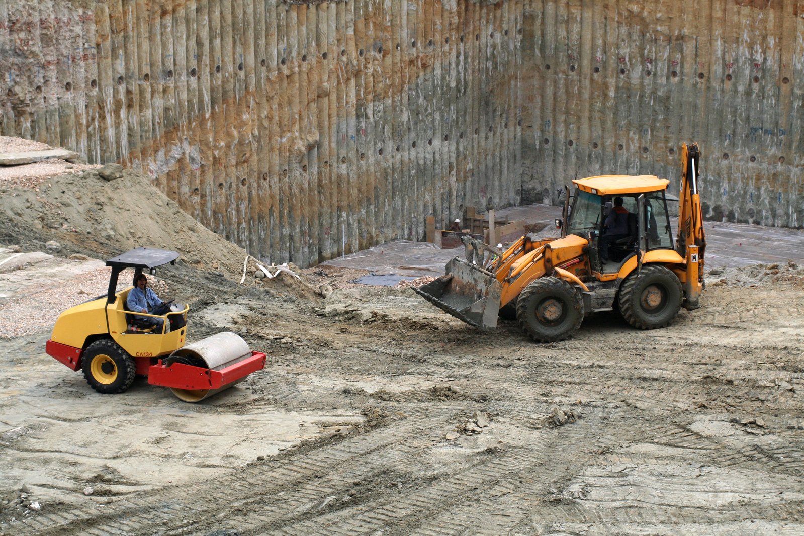 a man drives a tractor through a construction site