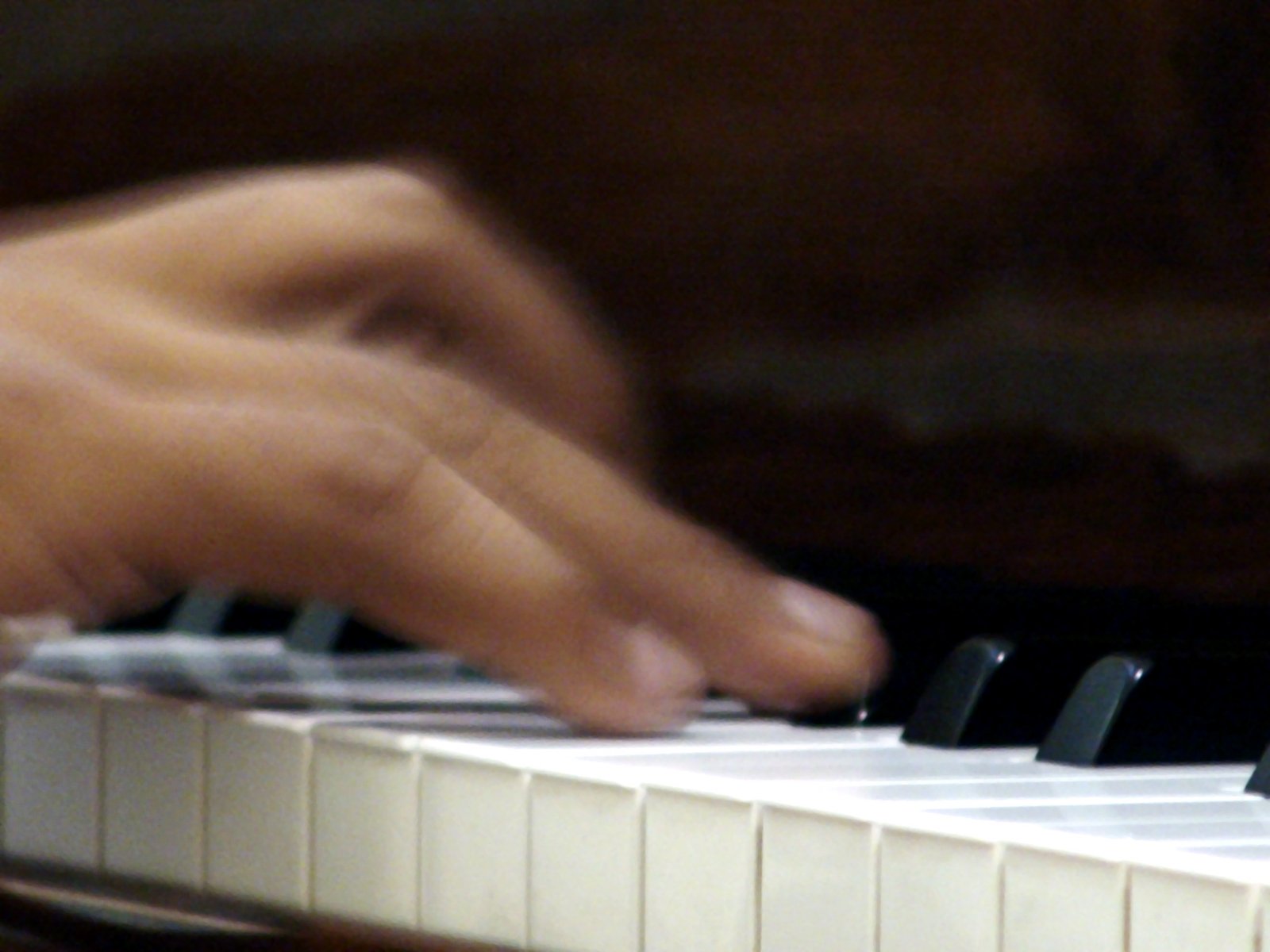 two hands are playing on a piano keyboard