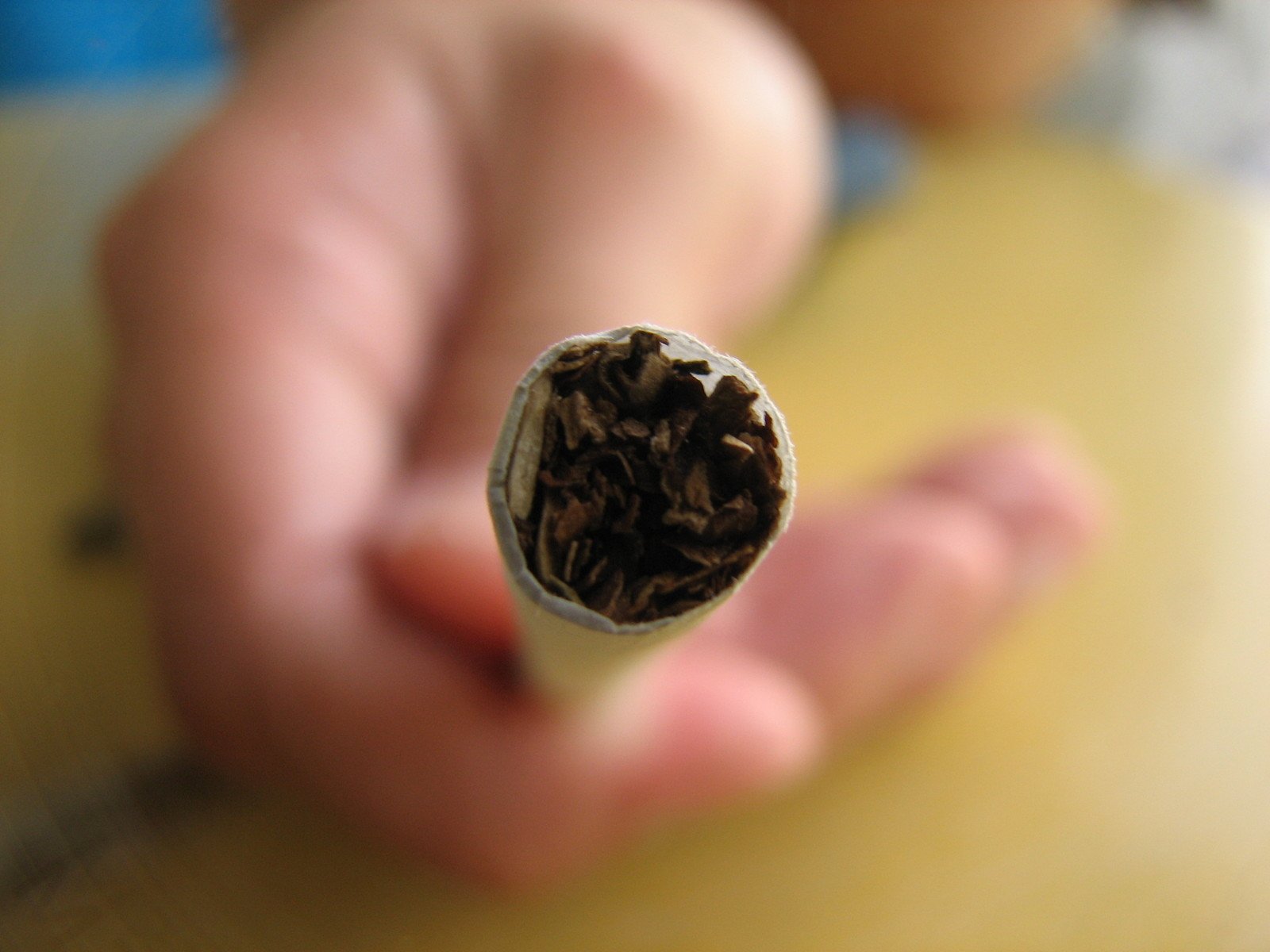 someone holding out a partially burned cigar on the table