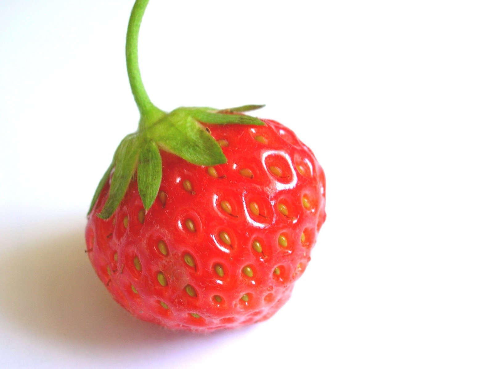 a close up of a red strawberry on a white table