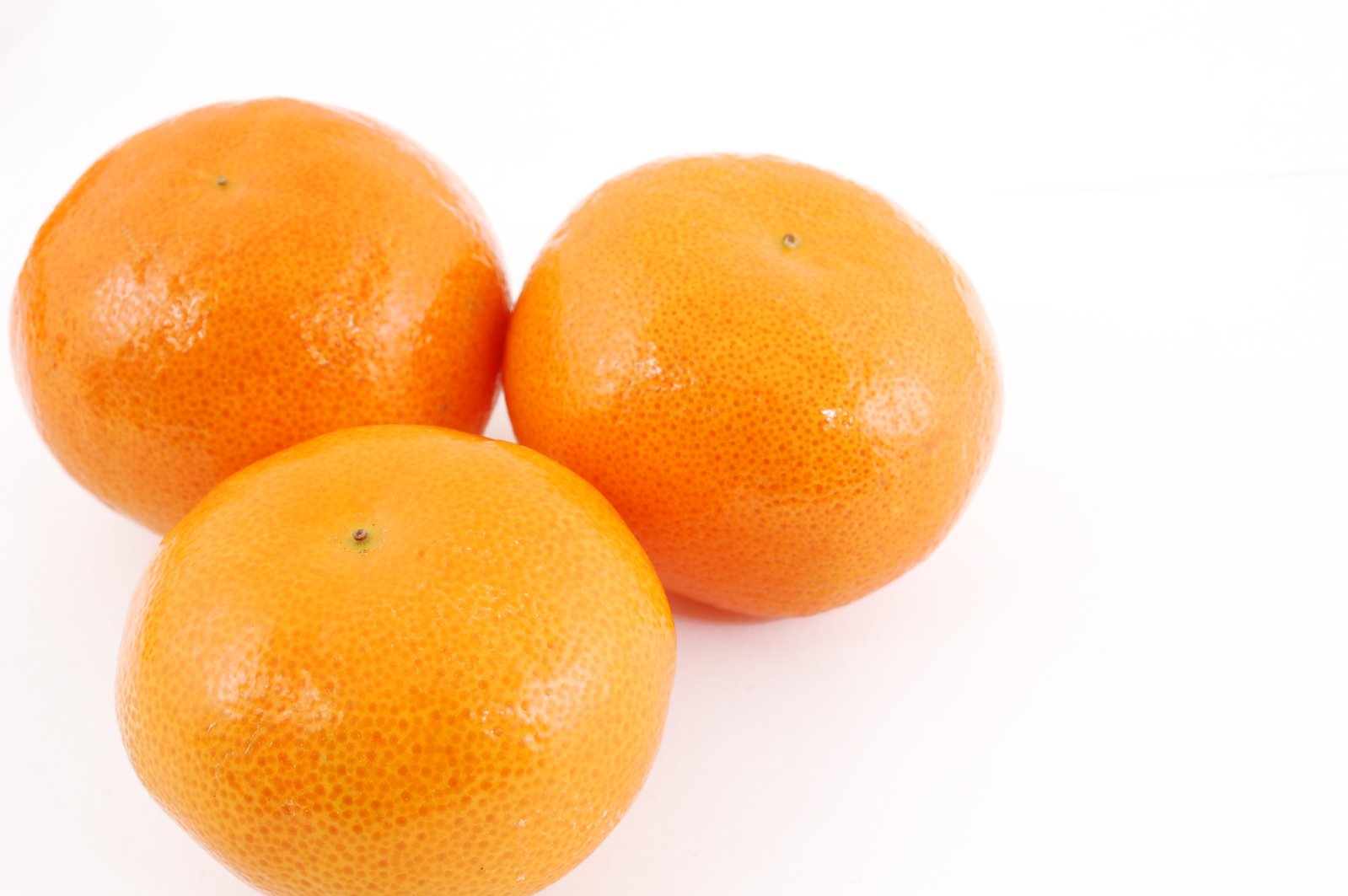 three oranges on top of each other next to each other