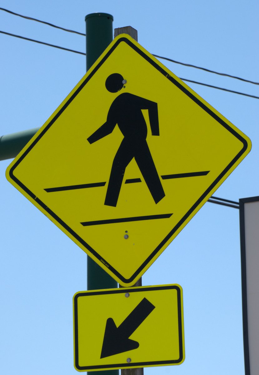 this is a crosswalk sign with an arrow above the walk and right arrow