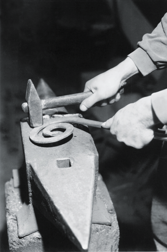 two hands using a mallet to work on soing