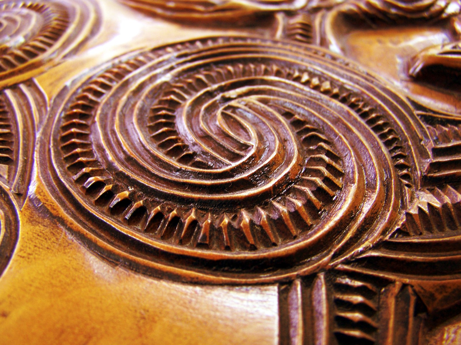 this is a wood carving with swirl designs on it