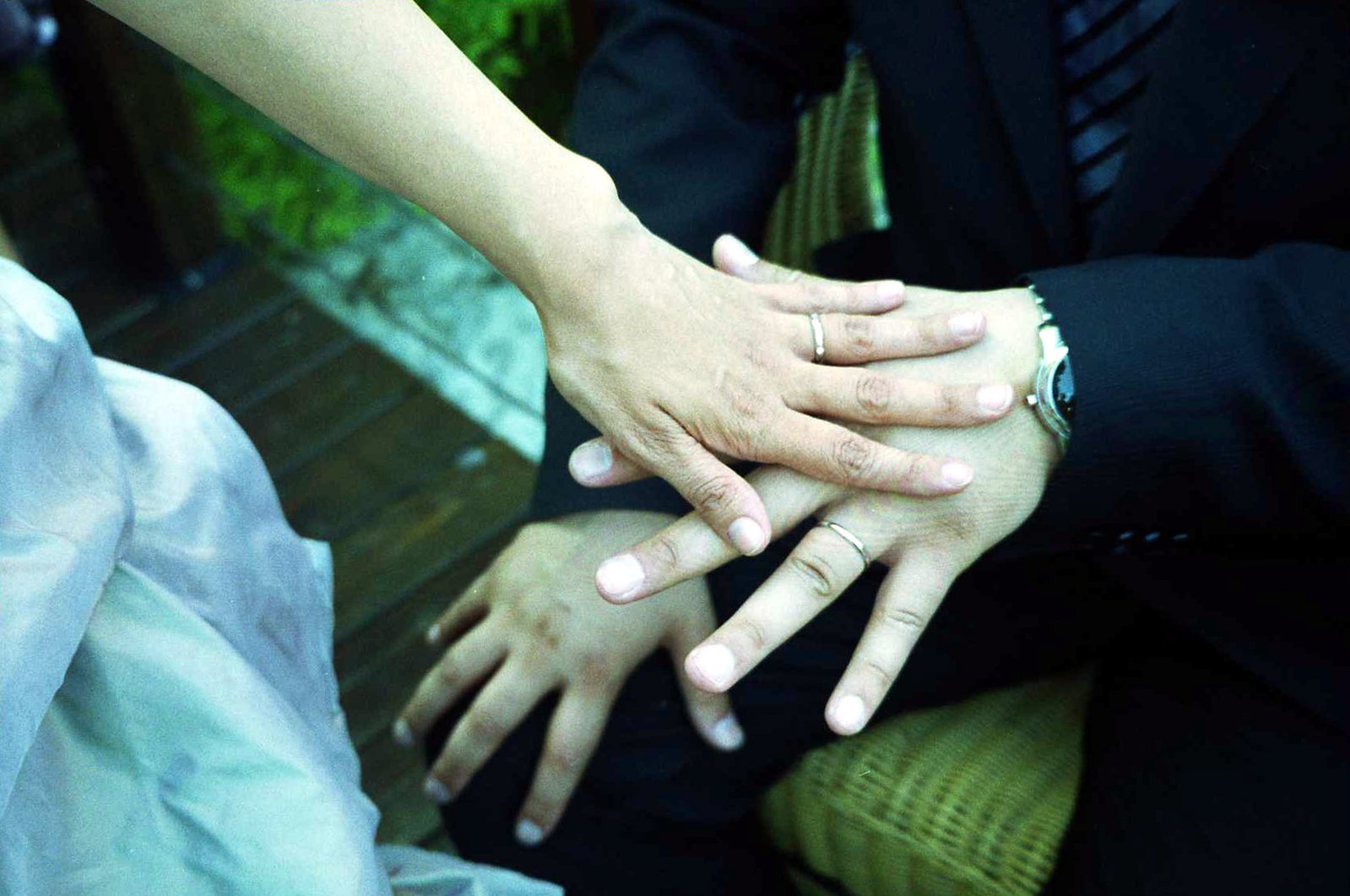 several people wearing suits holding hands in front of a bench