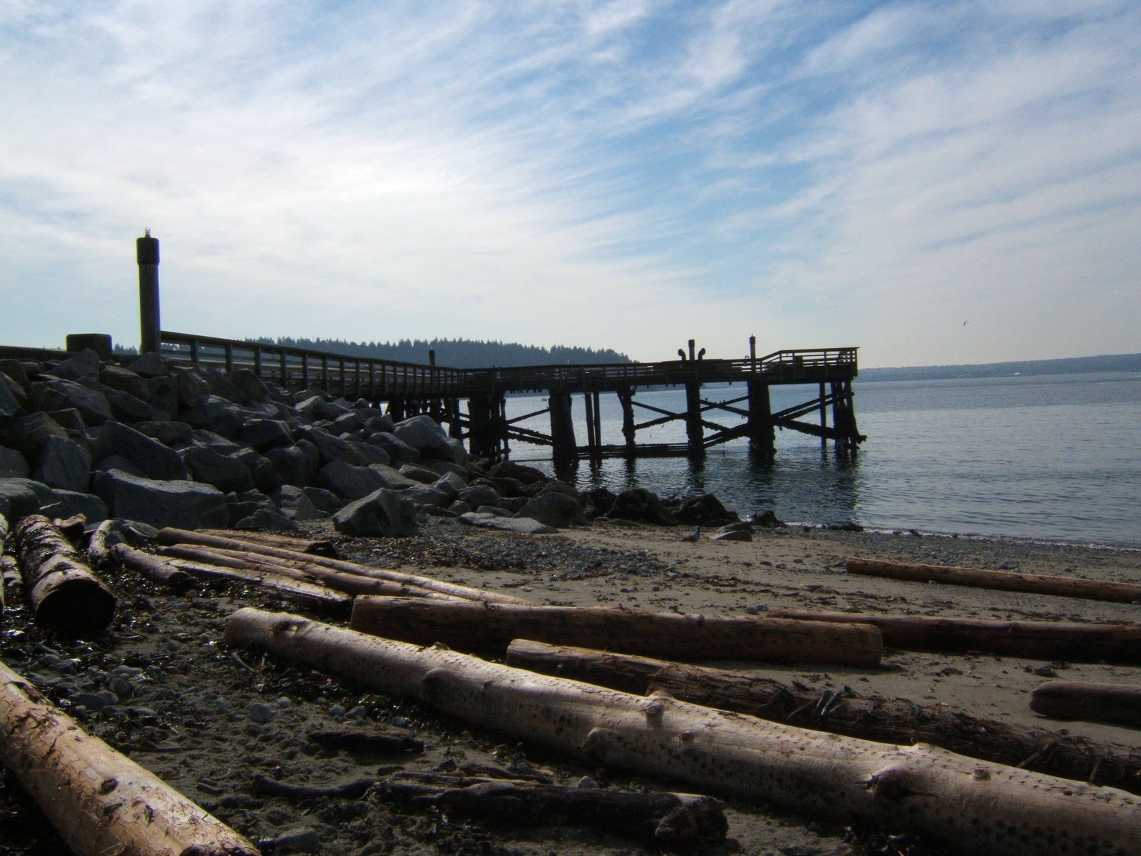 a wooden pier sitting on top of a sandy beach