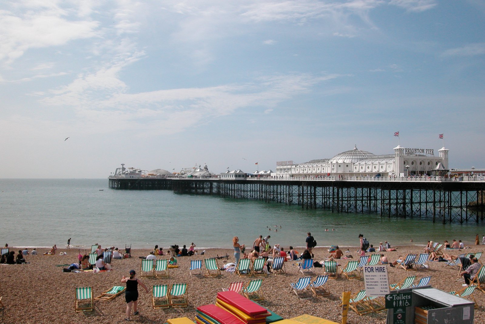 people sitting and standing around at the beach