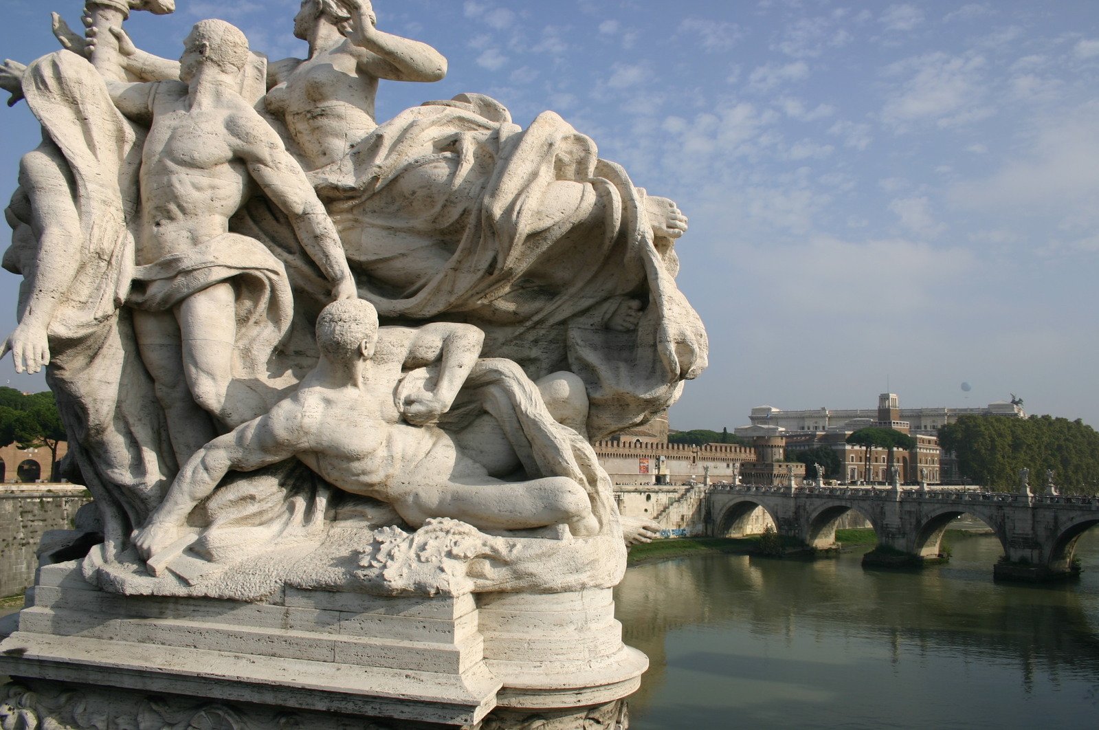 a statue of people with a bridge behind them