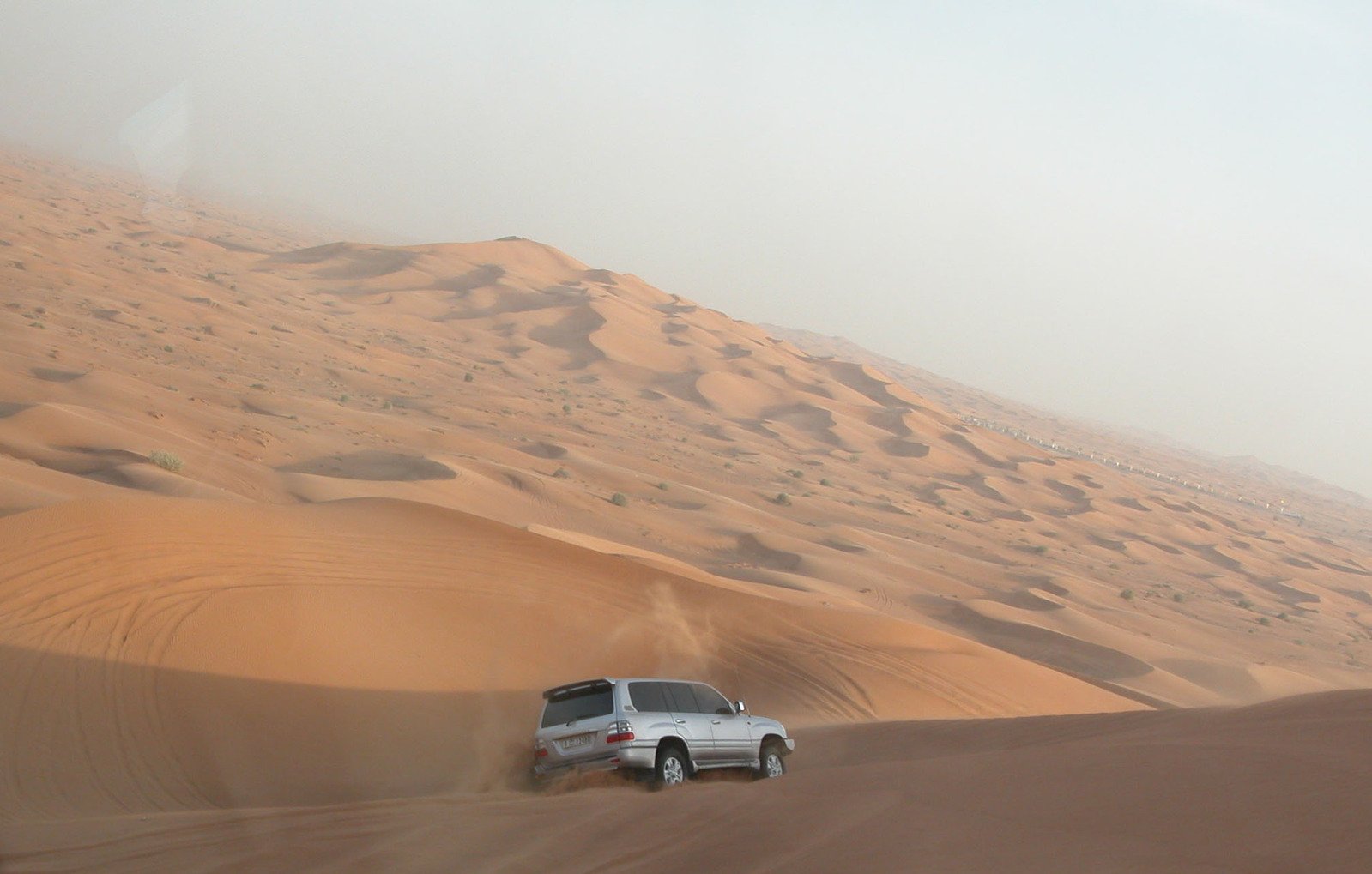 the car is riding across the desert by itself