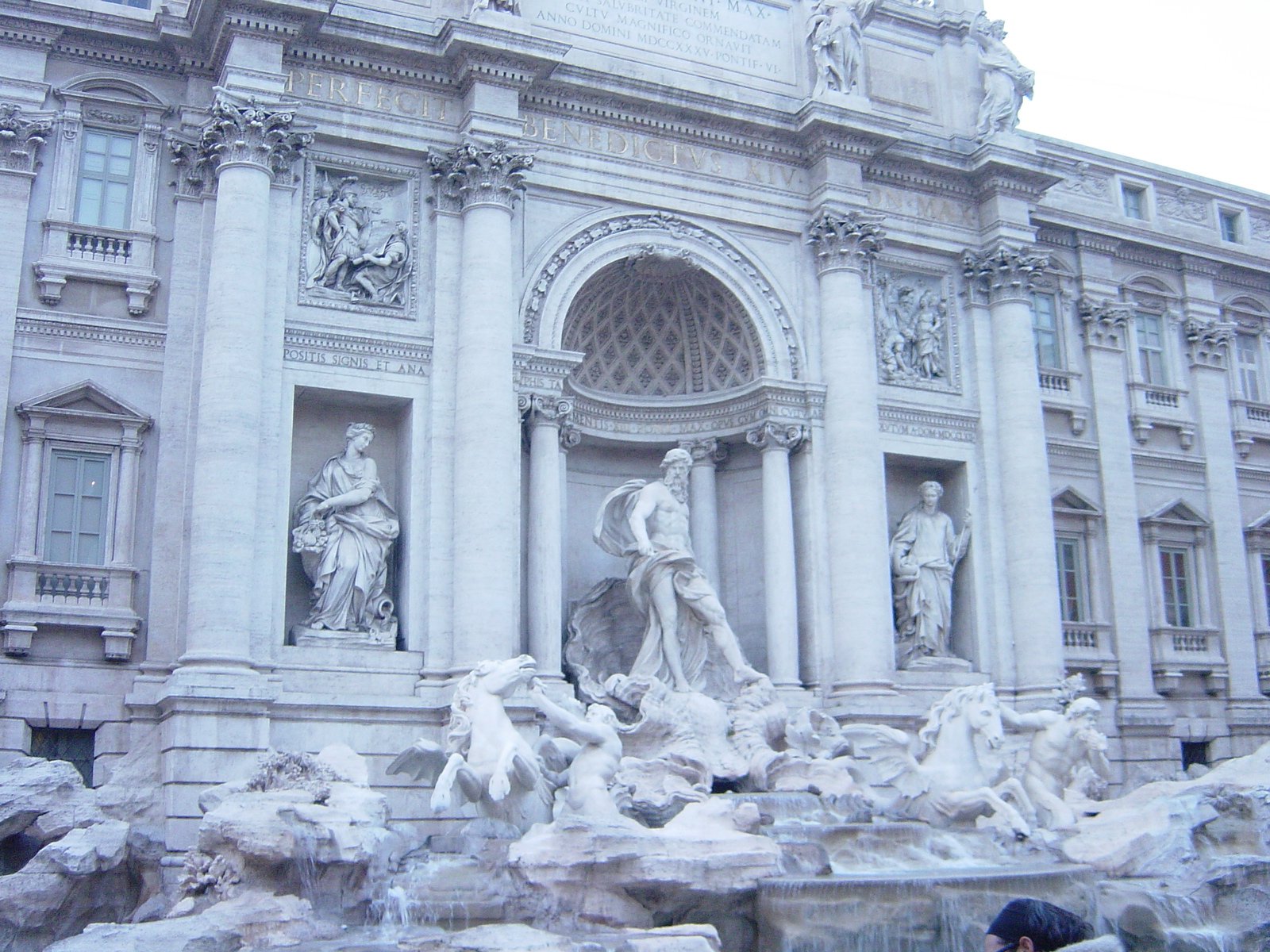 a large white building with fountains and statues in front of it