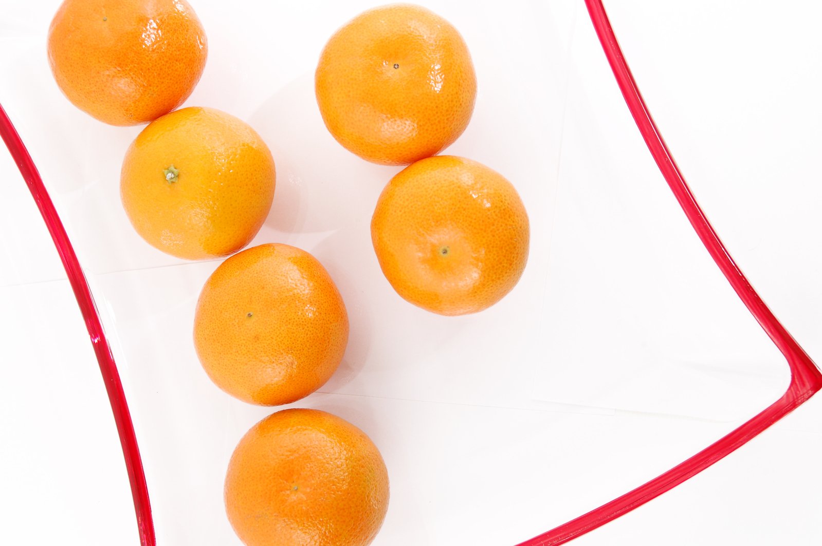 four oranges on a napkin on a white surface