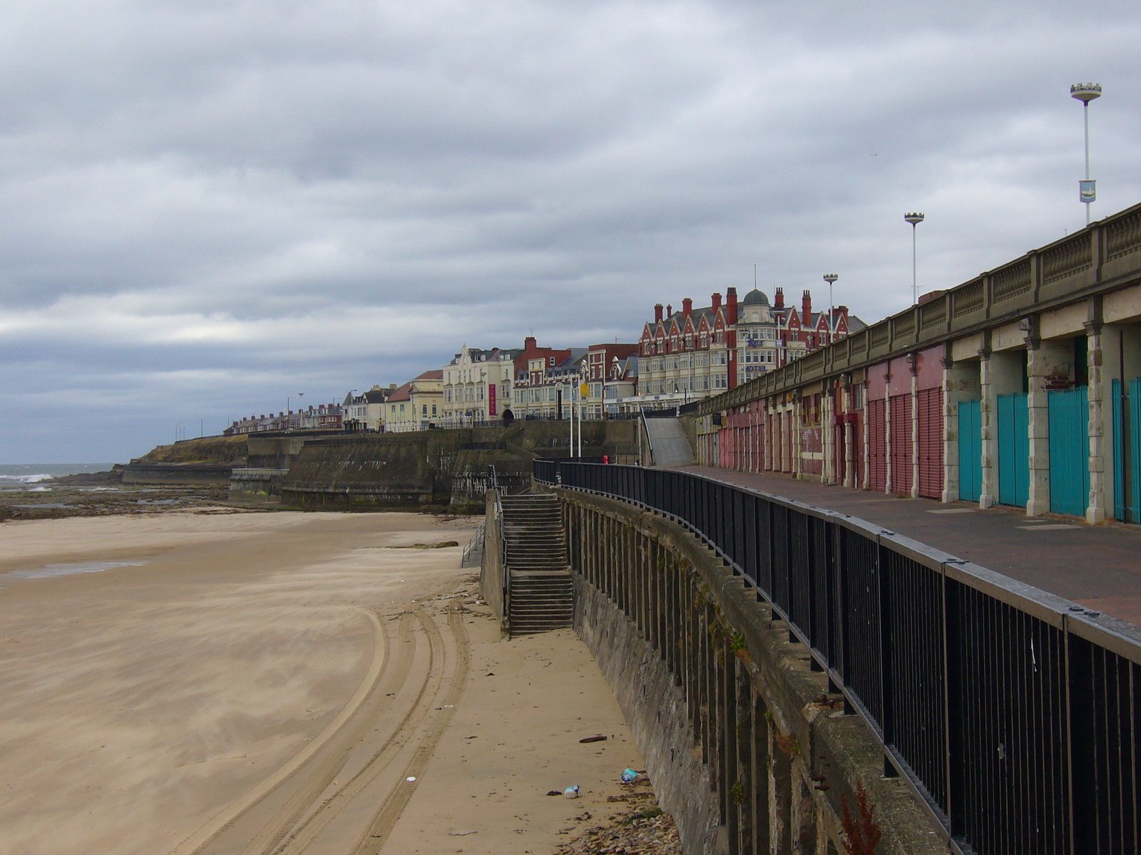 a fence is near the beach on a gloomy day