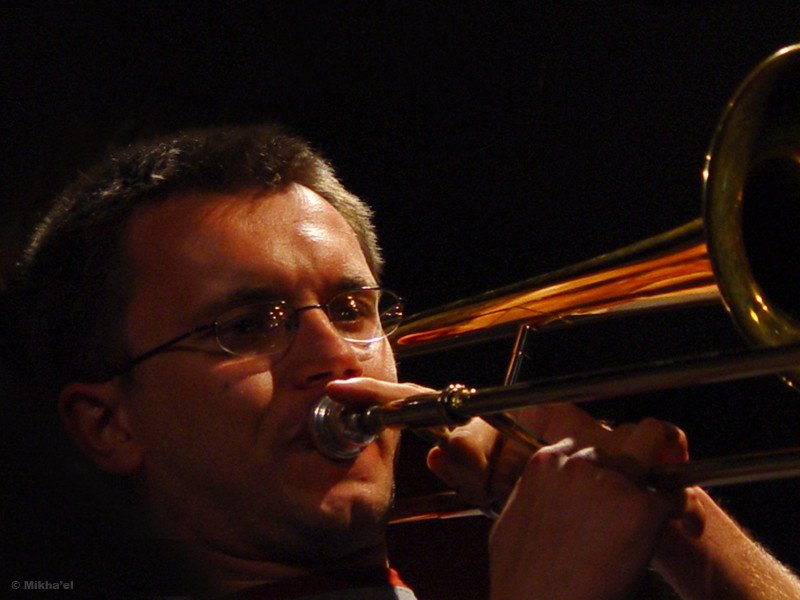 a man in glasses playing a trumpet on stage