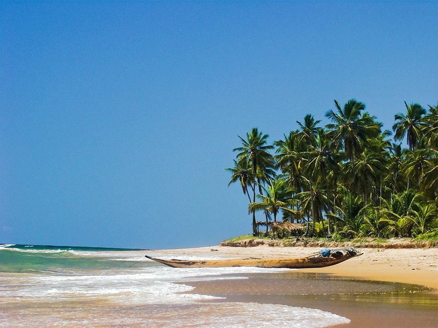 a couple of boats on a sandy beach next to water