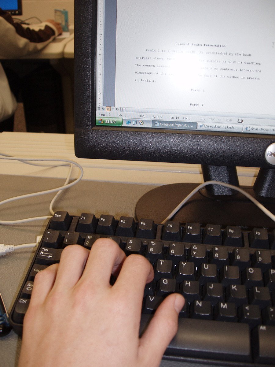 a hand using a keyboard on a computer