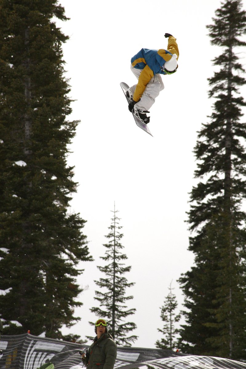 a man flying through the air on top of a snowboard