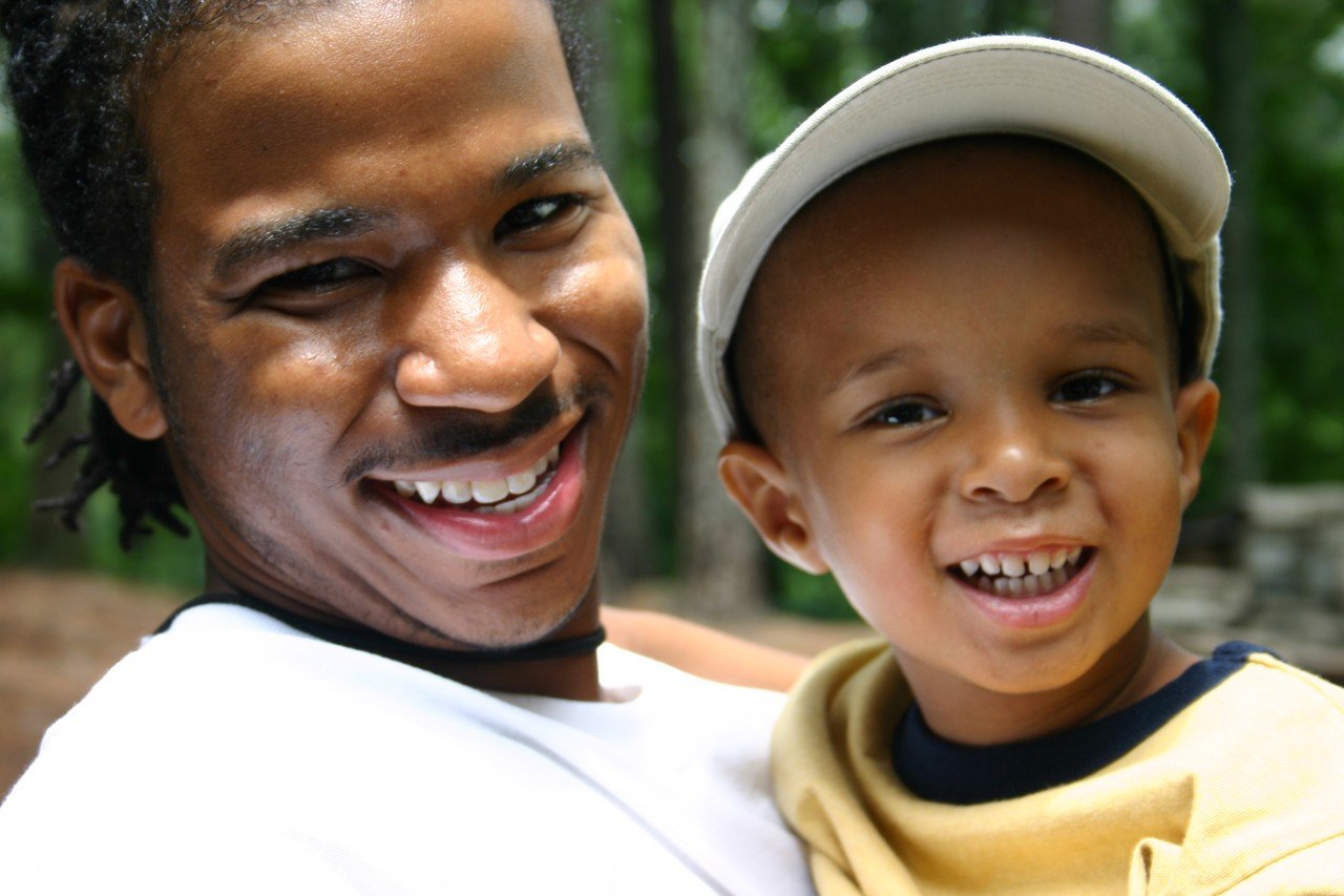 two young men posing for the camera in a wooded area