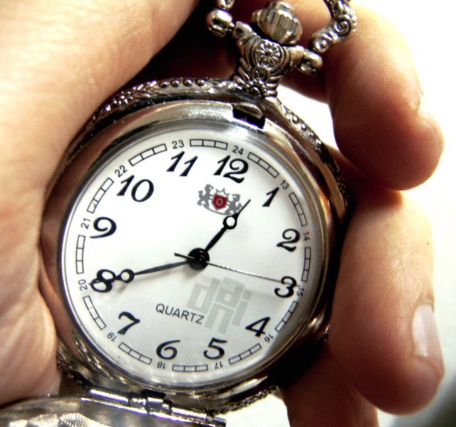 a close up of a person holding an antique pocket watch