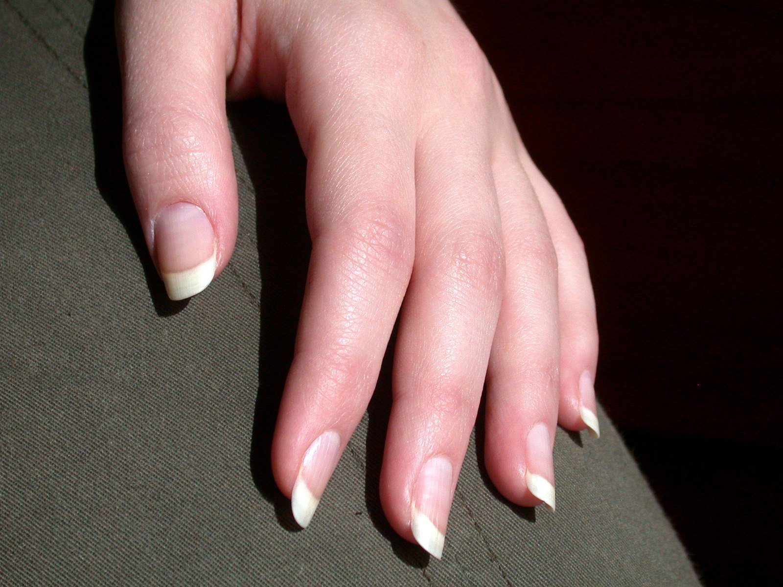 a woman is sitting down with a manicure on her finger