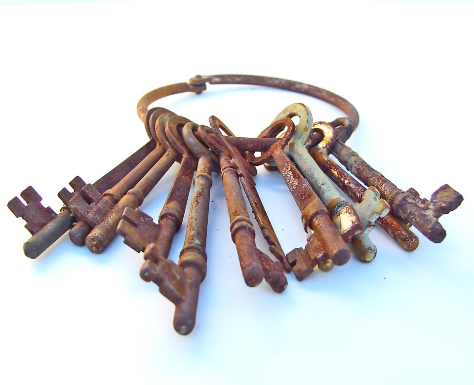 old rusty keys arranged on white surface