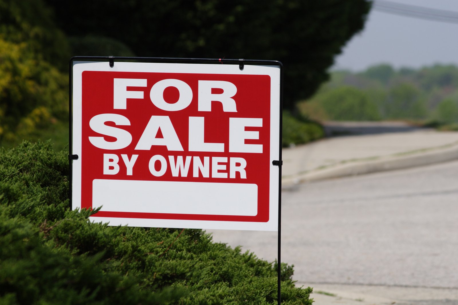 a for sale sign in a residential area of the town