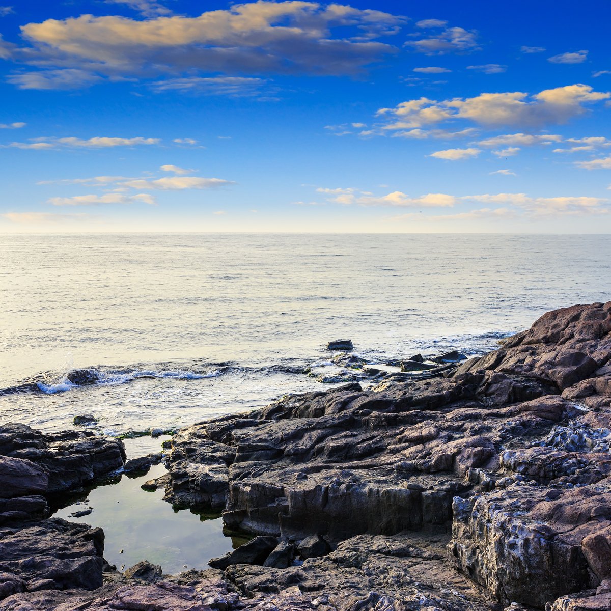 a long stone pier leading to the ocean