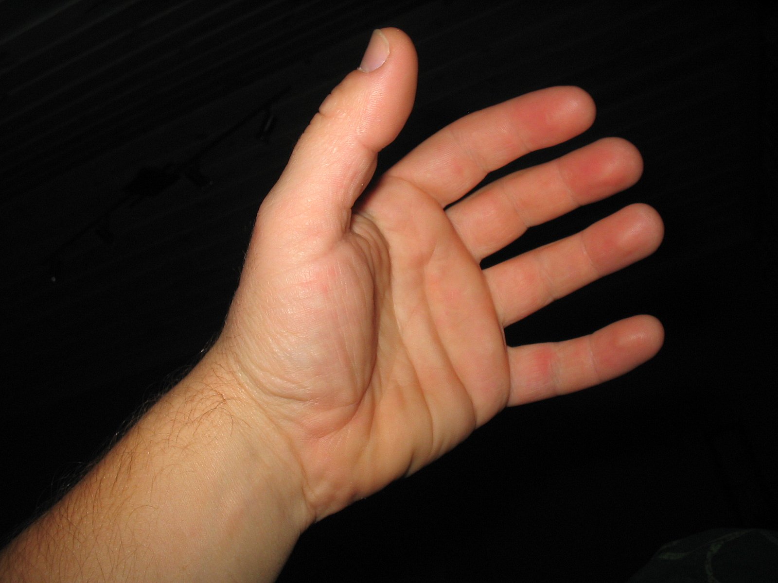 a close up of someone's hand against a black background