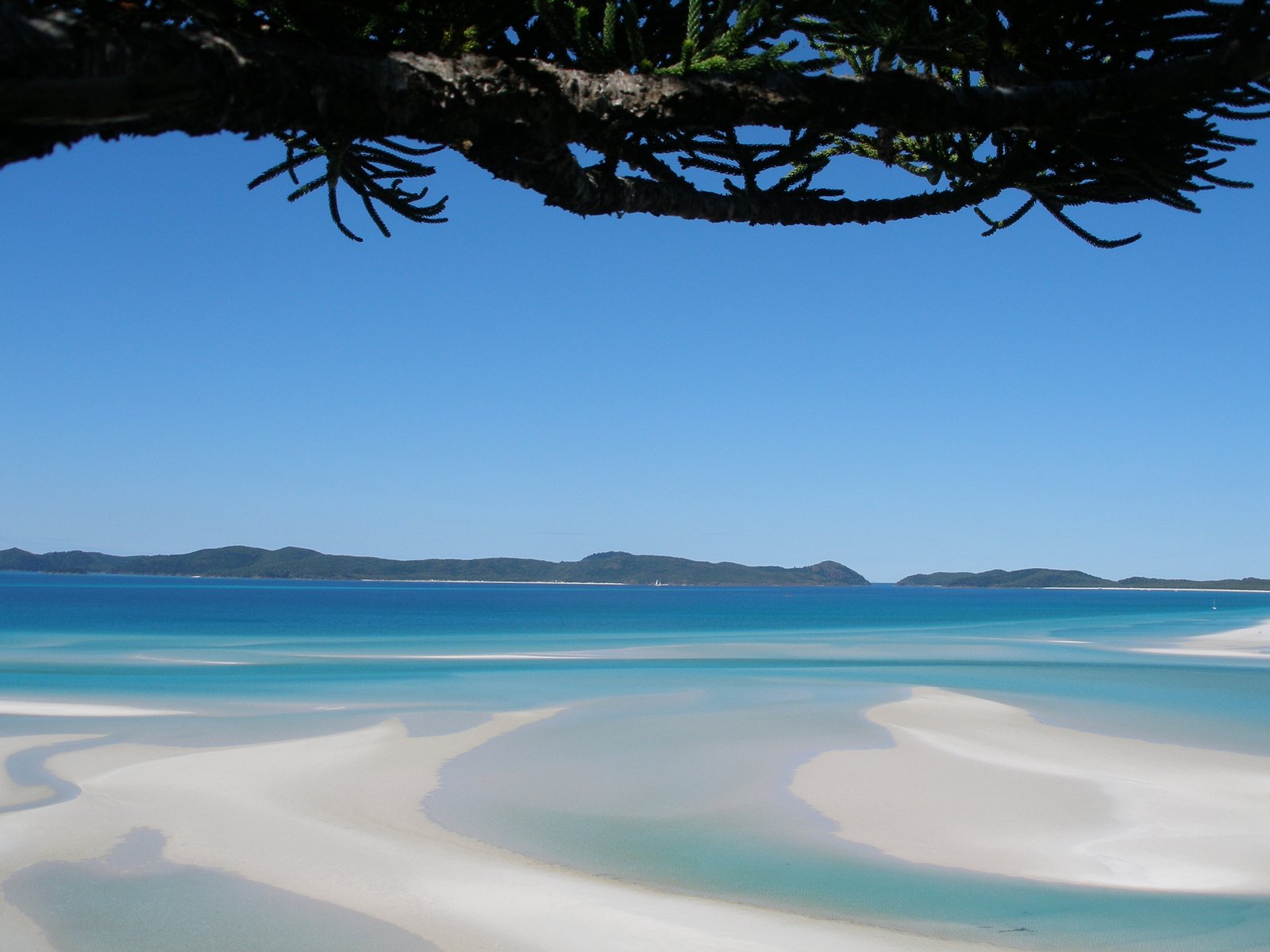 a beautiful blue ocean with some sand on it