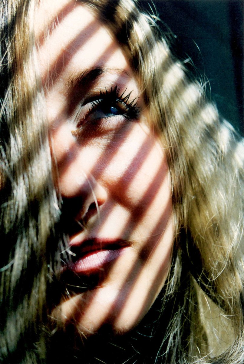 a woman with brown hair and blue eyes staring into the camera