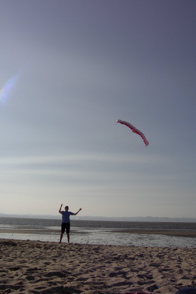 the man is flying a kite on the beach