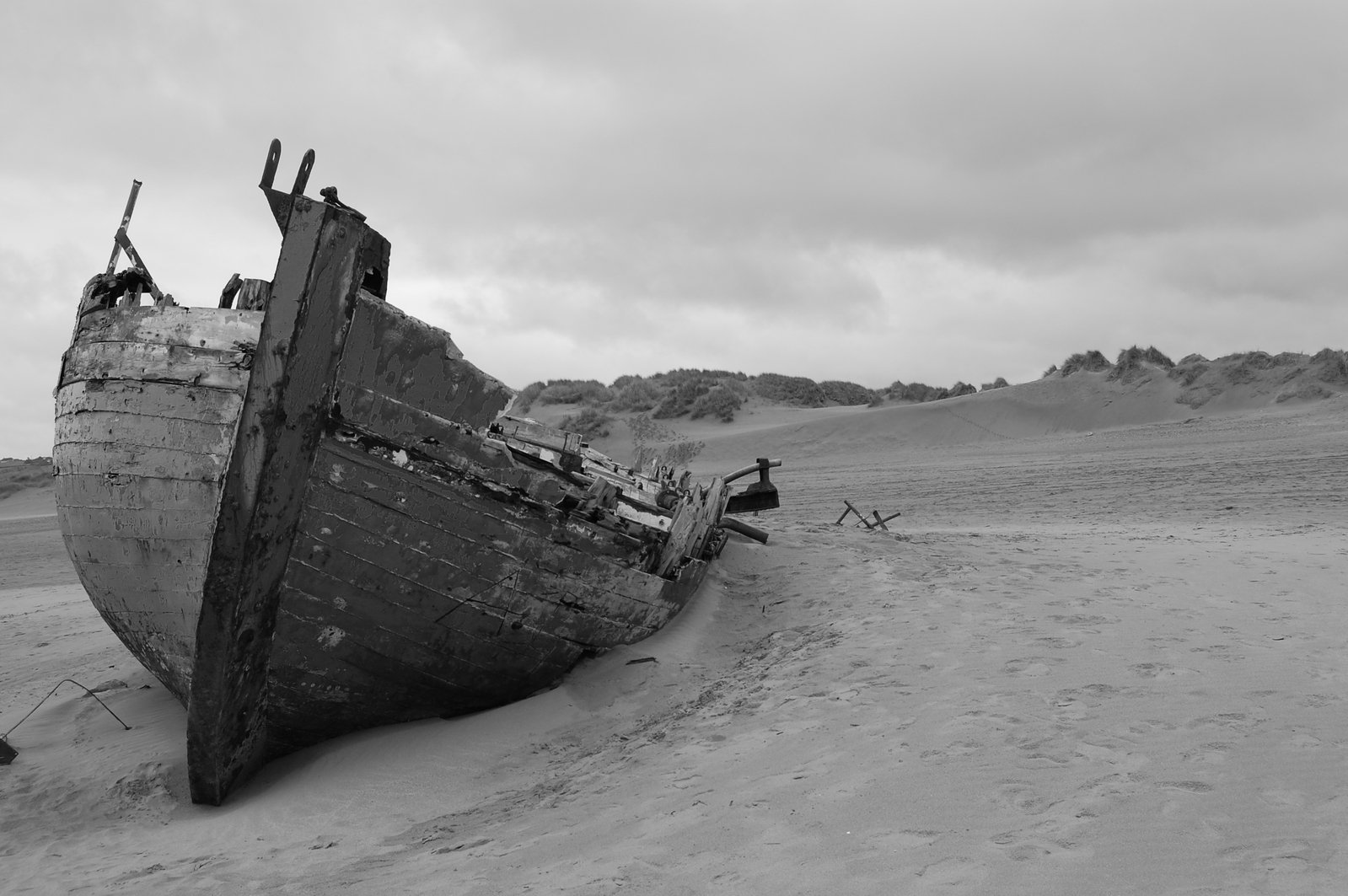 a small boat lying on a sand beach