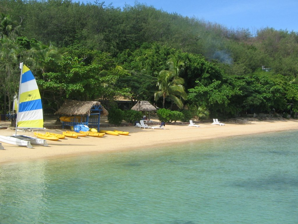 a small beach with many boats on the shore