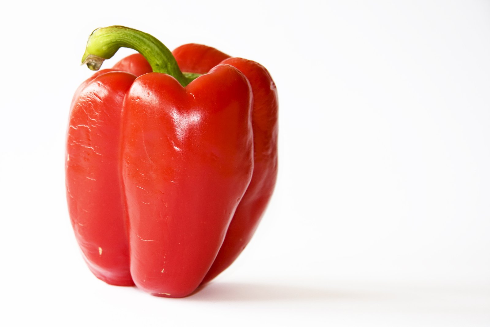 two red bell peppers are in focus against a white background
