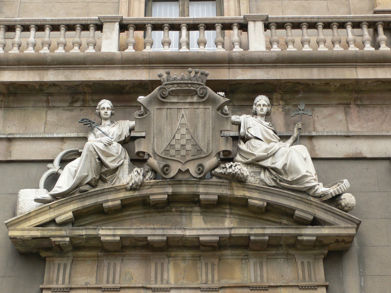 two statues holding a large shield and two people on the building