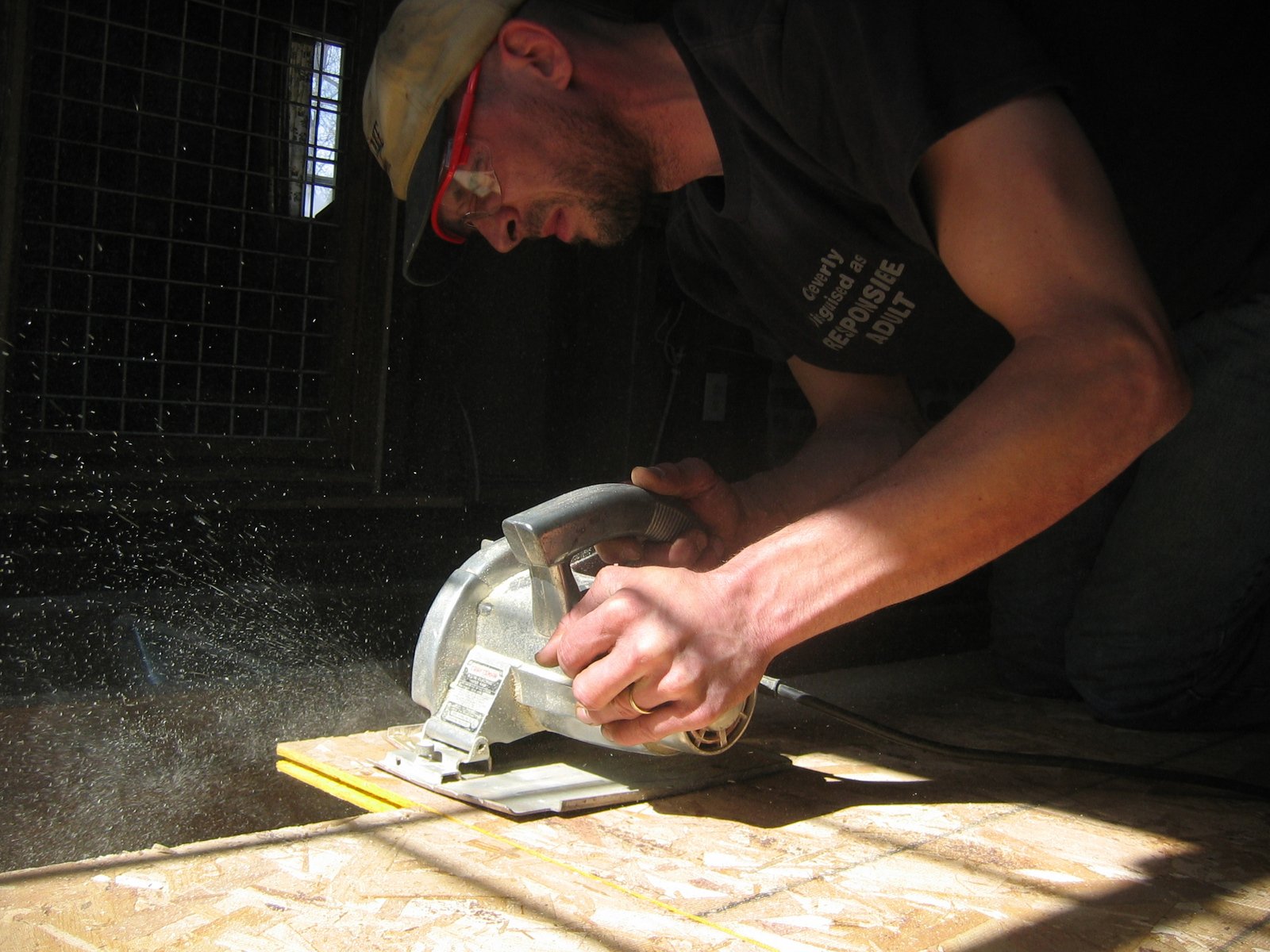 a man using a planer to sharpe down tile