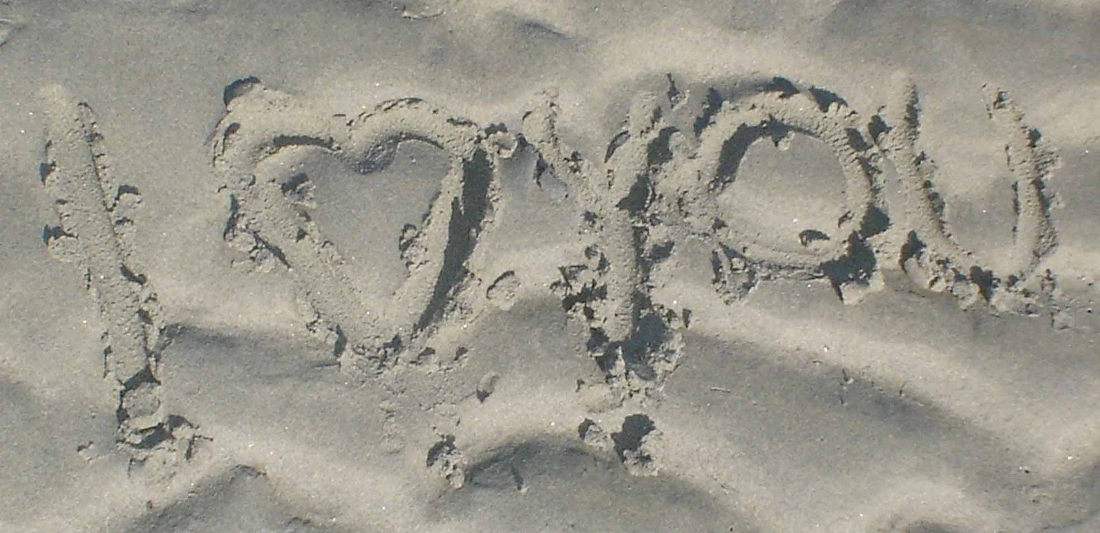 a close up of the word hope written in sand