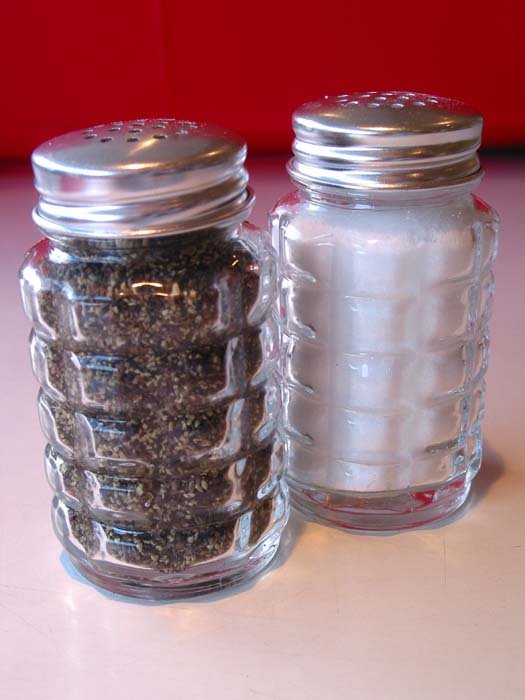 two glass jars full of spices next to each other