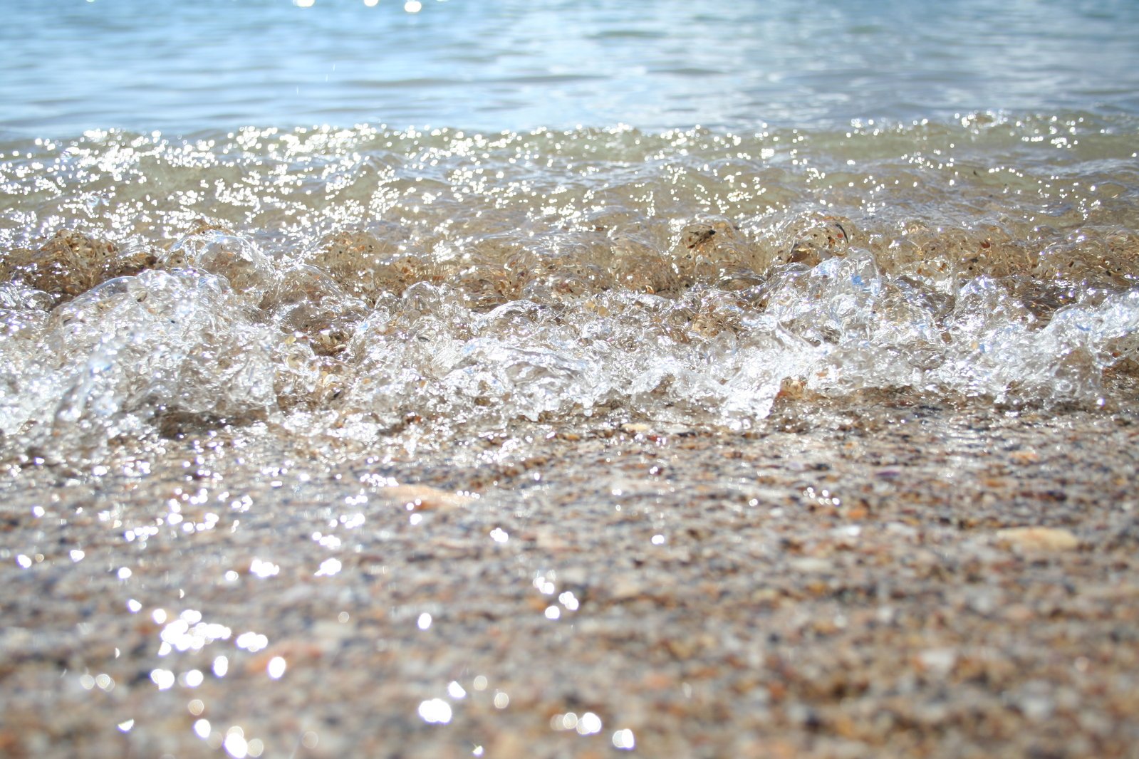 a beach with water coming out of the ocean