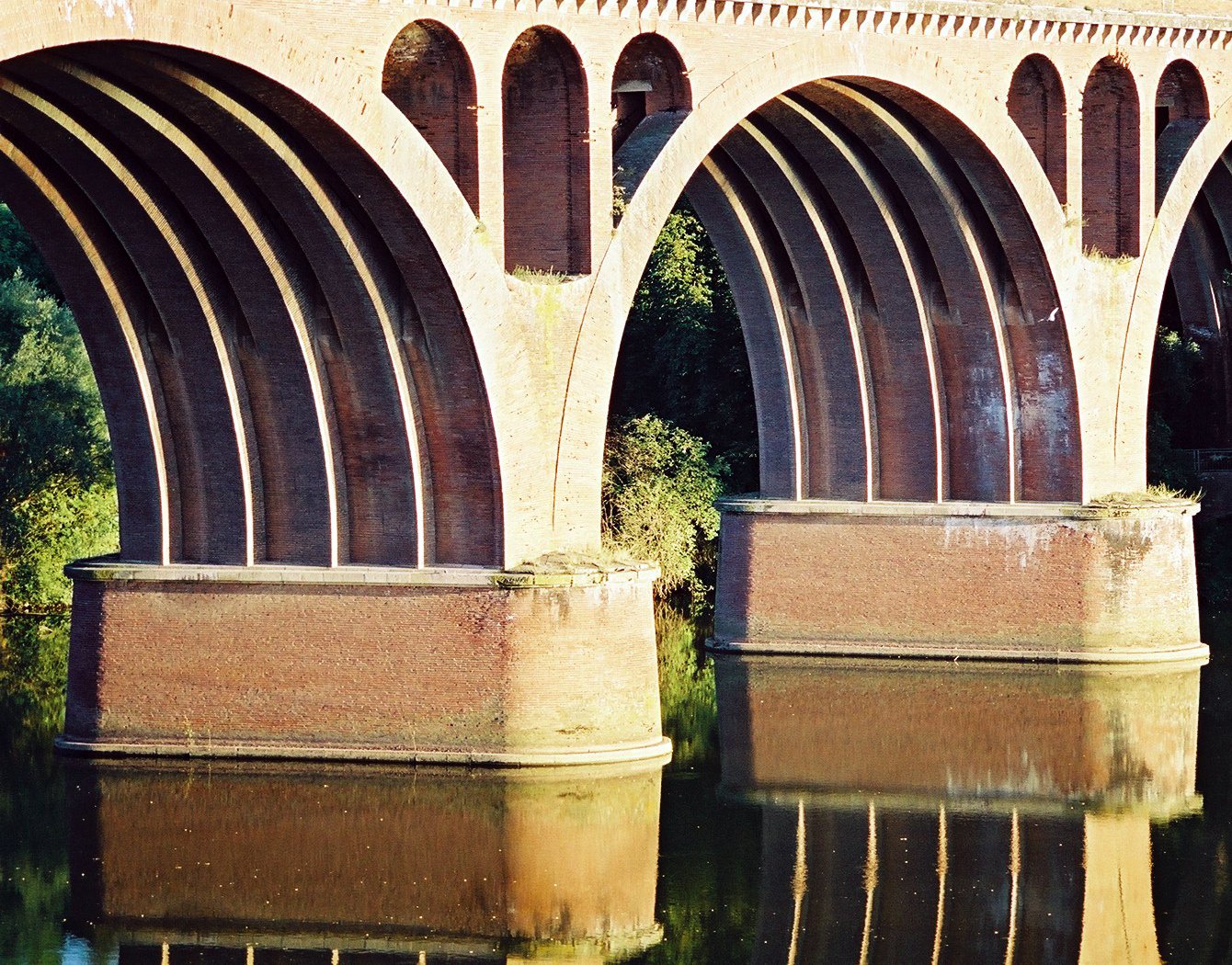 the arches and pillars are reflecting on the water