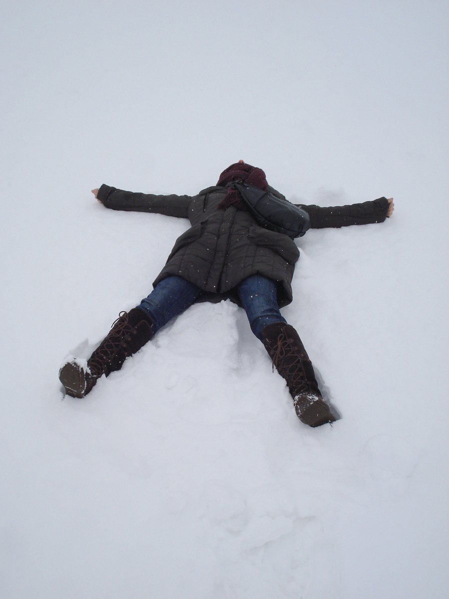 a person lying on their stomach in the snow