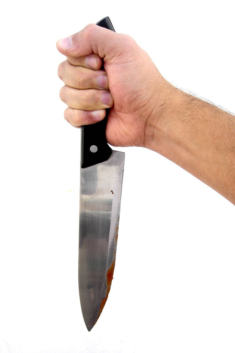 a mans hand holding a long knife with the blade off of it